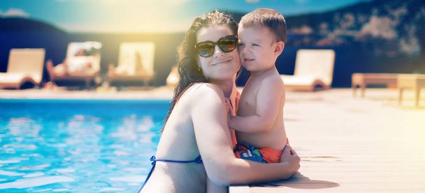 Banner Close-up of mother and son by the pool during summer vacation People sunbathing relax family day off - Photo, Image