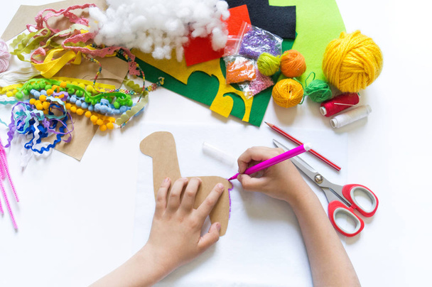 The hands of the child diy do handicraft toy lama. Felt soft craftsmanship. - Foto, Imagen