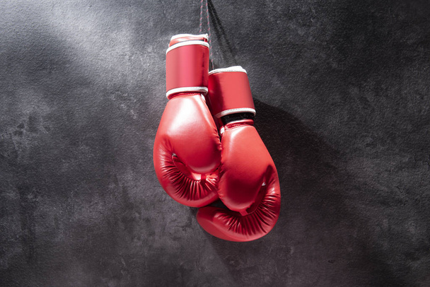 Pair of red boxing gloves hanging - 写真・画像