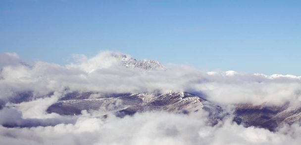 Felhők repülnek át a hó-Hegy - Fotó, kép
