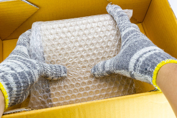hand of man hold Bubbles covering the box by bubble wrap  - Photo, Image