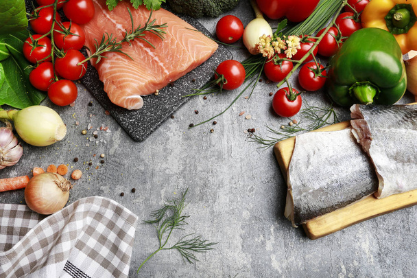 Raw salmon fillet and colorful vegetables on grey stone backgrou - Fotó, kép
