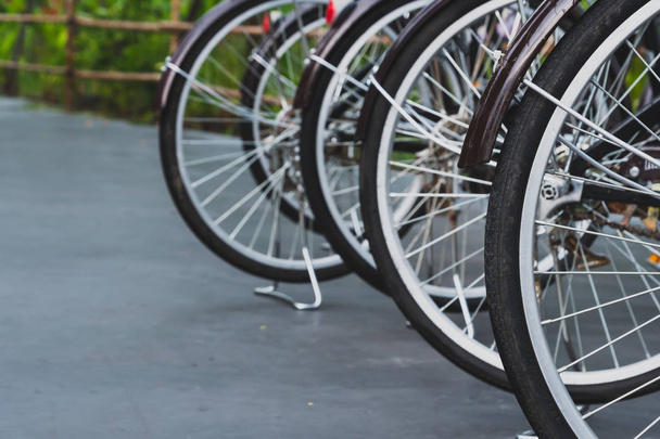 Close up of the dark brown antique bicycle wheels parked in rows - Fotó, kép