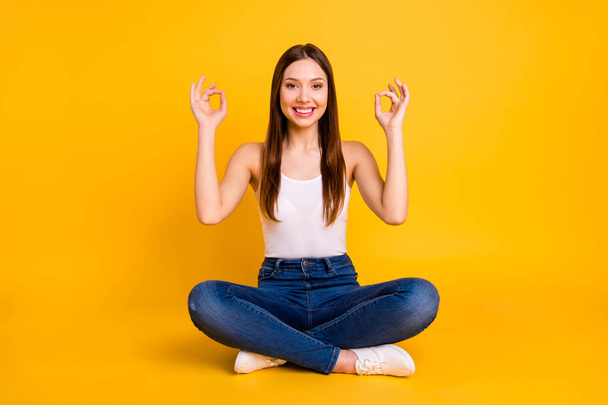 Portrait of charming lovely youth have fitness exerices feel content rejoice dressed modern top sneakers denim jeans she her isolated yellow colorful background - Foto, afbeelding