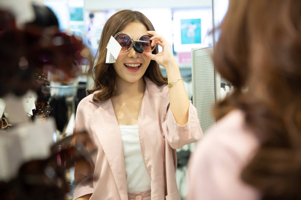 Lächelnde Asiatin mit Modebrille in Einkaufszentrum - Foto, Bild