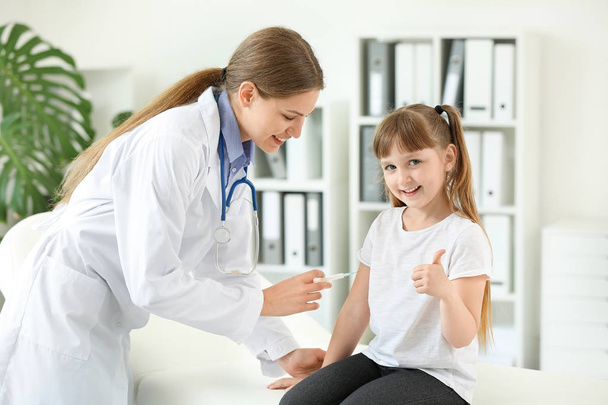 Dokter vaccineren klein meisje in kliniek - Foto, afbeelding