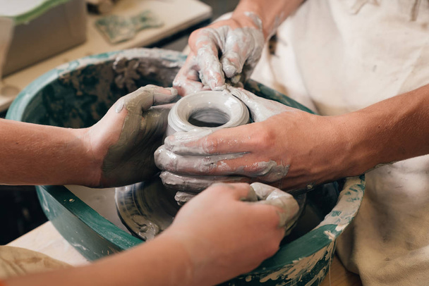 Мужчина и женщина занимаются гончарным делом в студии. Создание вазы. H
 - Фото, изображение
