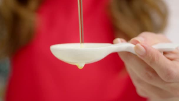 close up of woman pouring oil in white spoon  - Footage, Video