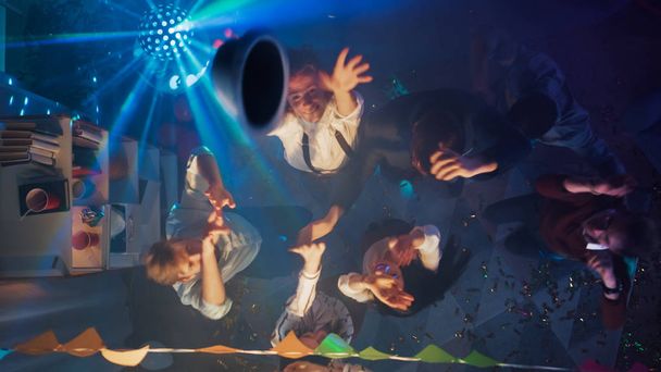 At the College Party: Diverse Group of Friends Have Fun, Dance, Socialize and Drink. Stylish Young People Dance Energetically in the Living Room. Disco Neon Lights. Top Down Shot. - Foto, imagen