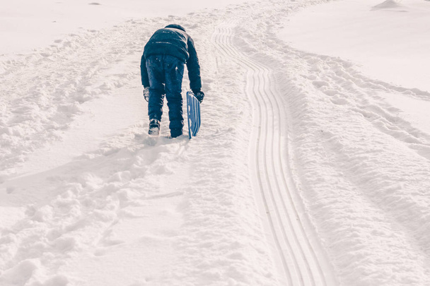 Тропа саней на снежном склоне горы, зимняя снежная морозная погода
 - Фото, изображение