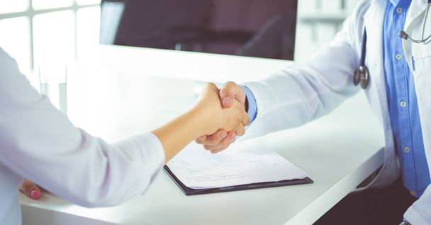 Doctor shaking hands to patient in the office at desk - Photo, Image