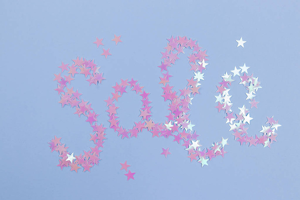 Sana "Myynti" tehty glitter confetti muodossa tähdet sinisellä pohjalla. Konsepti myyntiä varten
. - Valokuva, kuva
