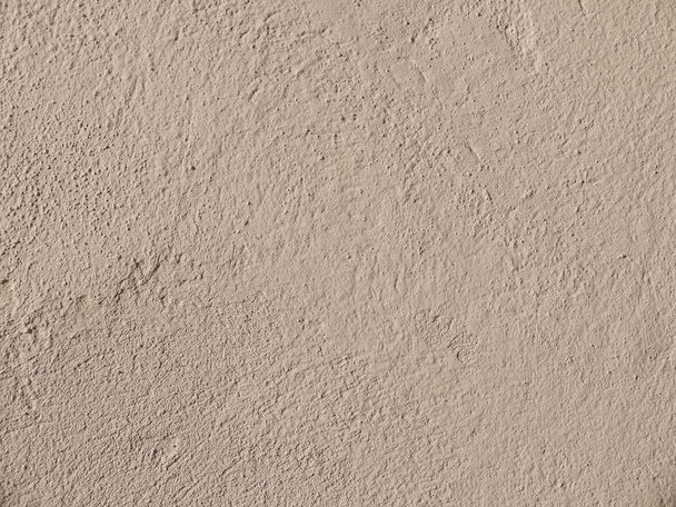 Textured grinded plaster in dark beige. Background or texture seamless pattern - Photo, image