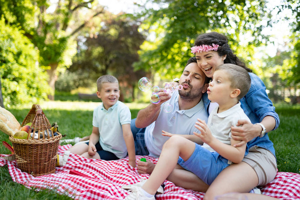 Happy multi generation family enjoying picnic in a park - Фото, зображення
