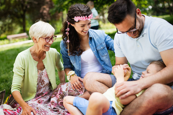 Счастливая семья из нескольких поколений наслаждается пикником в парке - Фото, изображение