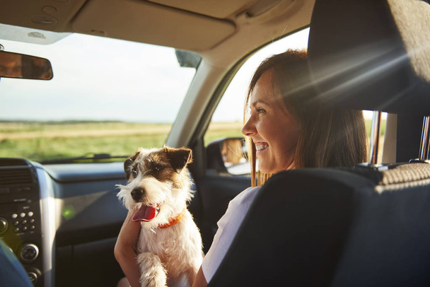 Fiatal nő és kutyája együtt utazik  - Fotó, kép
