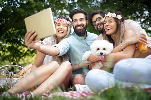 Щасливі молоді люди беруть селфі на пікнік на відкритому повітрі
 - Фото, зображення