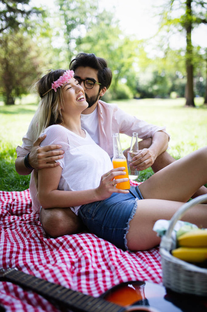 Happy couple in love enjoying picnic time outdoors - Foto, Imagen