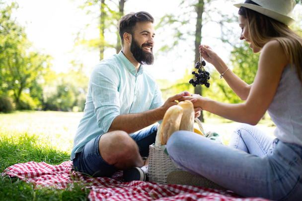 Beautiful young couple enjoying picnic day. Lifestyle, love, dating, vacation concept - Foto, Imagem
