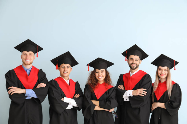 Fiatal hallgatók Bachelor köpenyes színes háttér - Fotó, kép