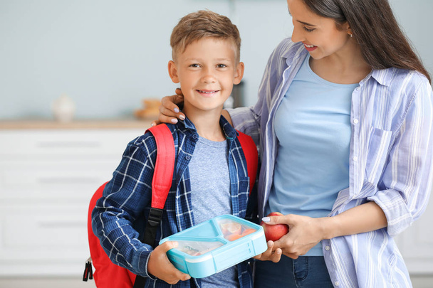 Mutter und ihr kleiner Sohn mit Brotdose vor der Schule - Foto, Bild