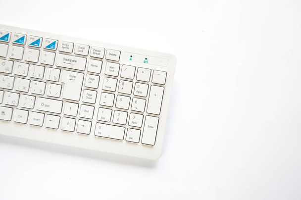 Clavier d'ordinateur blanc repose sur la table sur un fond blanc
. - Photo, image