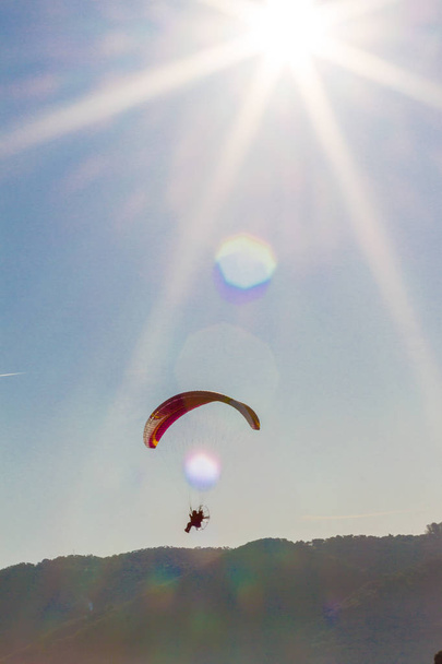 por do sol com parapente piloto voando sobre nuvens
 - Foto, Imagem
