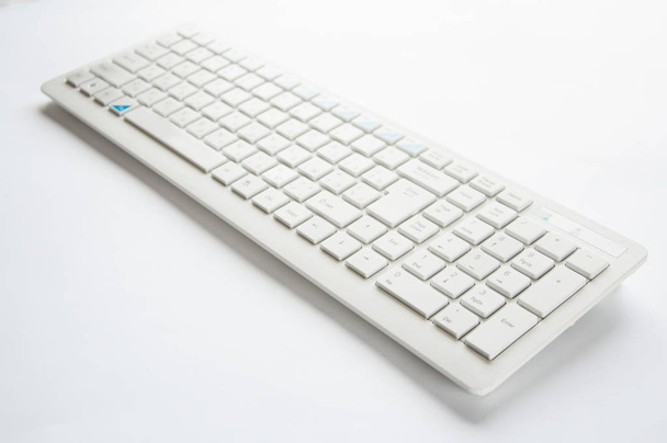 White computer keyboard lies on the table on a white background. - Photo, Image