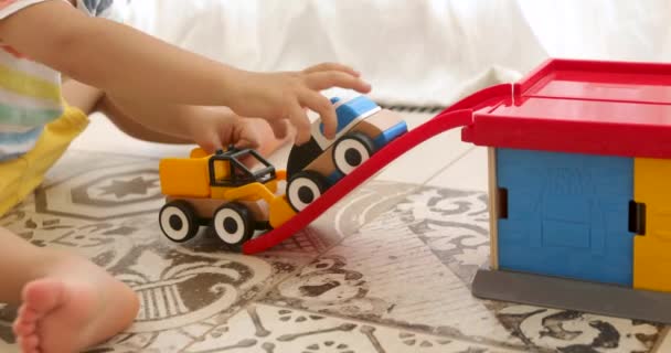 Crop child play with wooden toy cars - Filmagem, Vídeo
