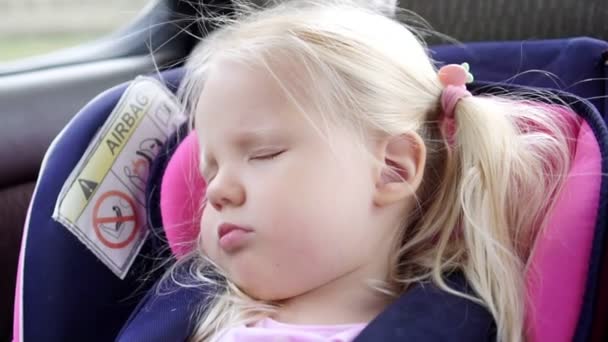 Bebê menina passeios no carro e dorme em uma cadeira auto criança, close-up
. - Filmagem, Vídeo