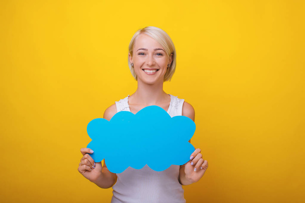 Cheerful blonde woman holding a speech cloud, standing over yell - Fotoğraf, Görsel