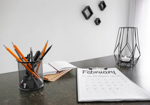 オフィステーブルにカレンダーと文房具が付いている紙シート - 写真・画像