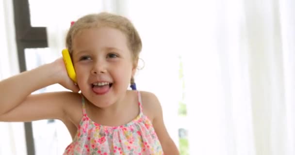 Emotioneel meisje praten op een speelgoed telefoon - Video