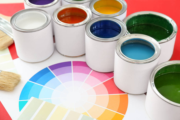 Cans of paints with palette samples on color background - Photo, Image