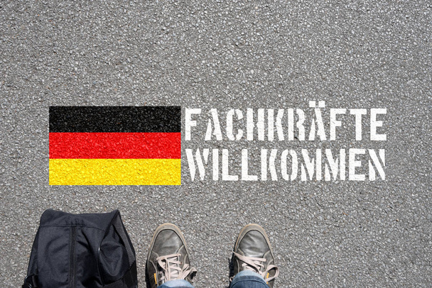 Ein Mann mit dem Koffer, deutsche Flagge und Slogan Fachkrfte Willkommen - Foto, Imagem