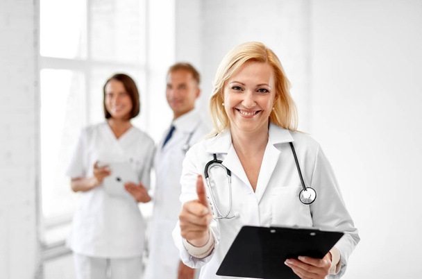 sonriente médico mostrando pulgares hacia arriba en el hospital
 - Foto, Imagen
