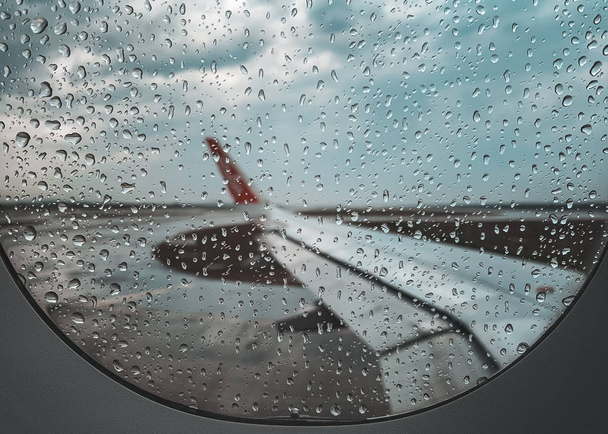 Rain drop at Airplane window before take off when monsoon season. - Photo, Image
