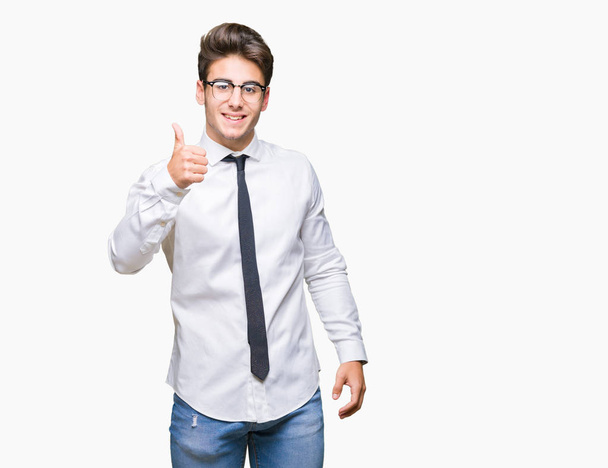 Молодий бізнесмен в окулярах над ізольованим тлом робить щасливі великі пальці вгору жестом рукою. Затвердження виразу, який показує успіх фотоапарата
. - Фото, зображення