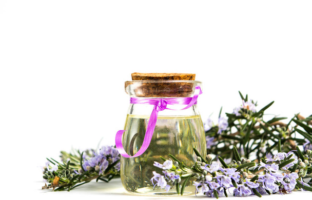 Aceite de romero en una botella con ramas de flores
 - Foto, imagen