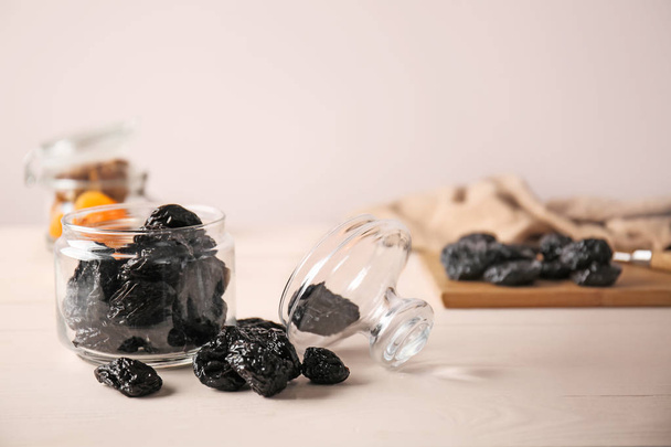 Jar with tasty prunes on light table - Fotografie, Obrázek