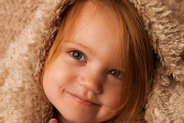 Niño pequeño sonriendo con manta
 - Foto, imagen