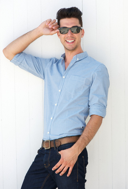 Beau jeune homme souriant avec des lunettes de soleil à l'extérieur
 - Photo, image