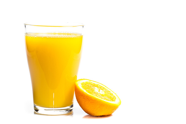 een glas sinaasappelsap en sinaasappelen - Foto, afbeelding