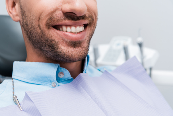 cropped view of happy patient smiling in dental clinic  - Photo, Image