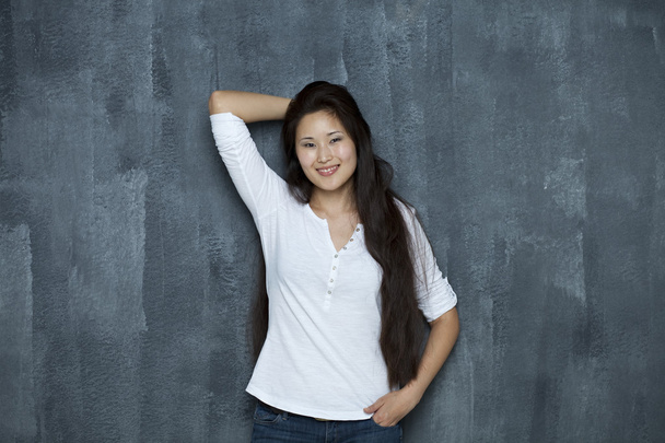 Asian young woman standing by wall - Foto, immagini