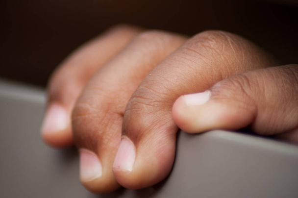 κοντινό πλάνο των αφρικανικών χεριών του μωρού που ποζάρει στο τραπέζι  - Φωτογραφία, εικόνα