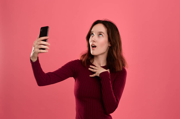 Foto van een mooie jonge brunette vrouw maken selfie met een mobiele telefoon. - Foto, afbeelding