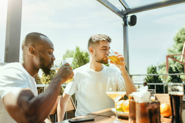 Young men drinking beer and celebrating together - Fotografie, Obrázek