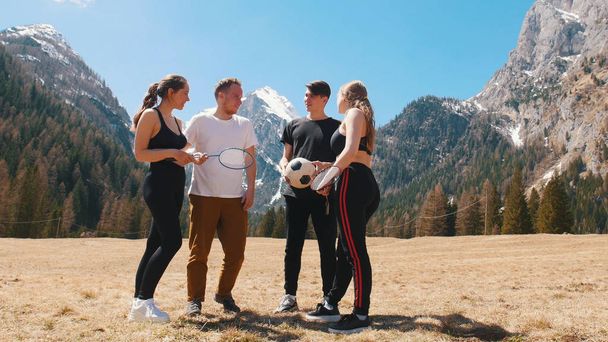 junge Gruppe sportlicher Freunde, die auf dem Feld stehen und reden - Dolomiten, Italien - Foto, Bild