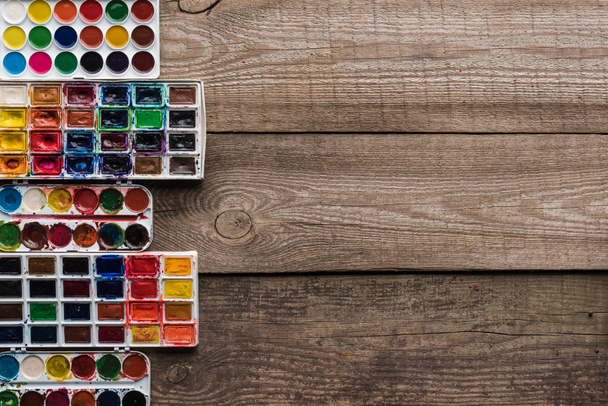 kopya alanı ile ahşap kahverengi yüzeyde renkli boya paletleri üst görünümü - Fotoğraf, Görsel